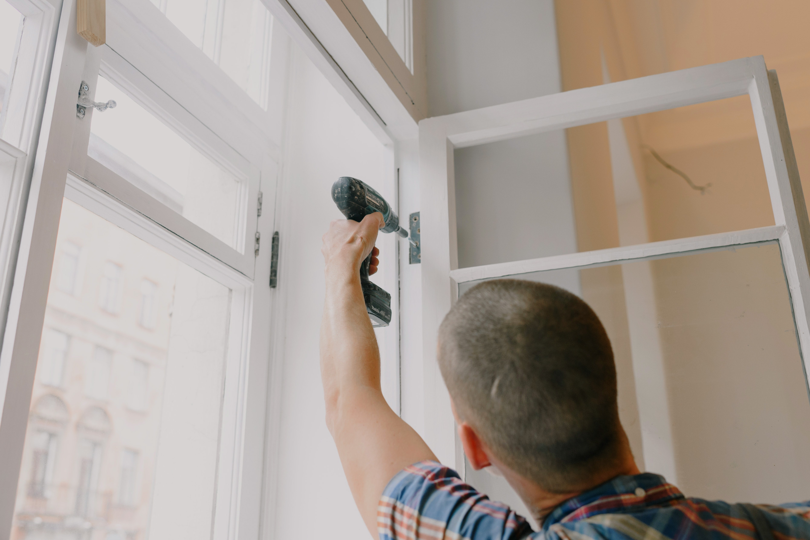 man installing window in room